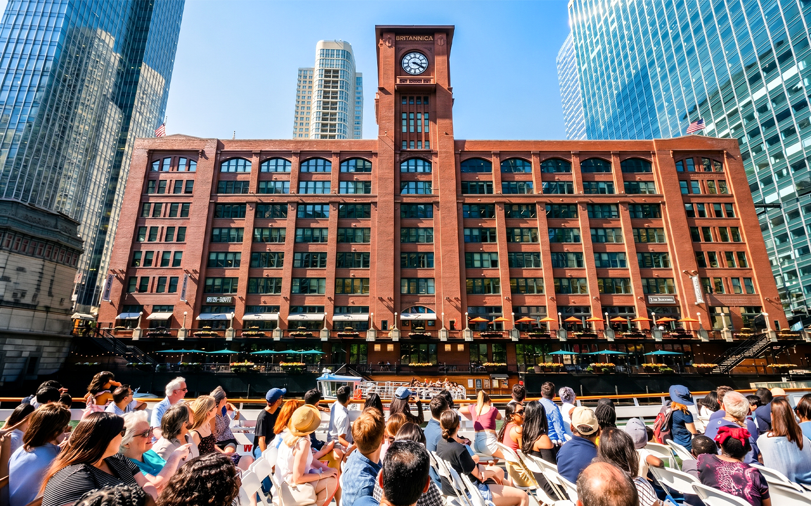 Tourists on a Chicago River cruise view the Britannica Building's clock tower.