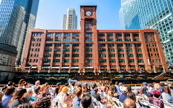 Tourists on a Chicago River cruise view the Britannica Building's clock tower.