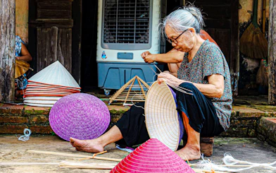 Craftsperson weaving traditional hats in Hanoi's Hat Making Village.