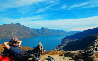 Quad biker relaxing with view of Lake Wakatipu and mountains, Queenstown Quad Bike Tour.