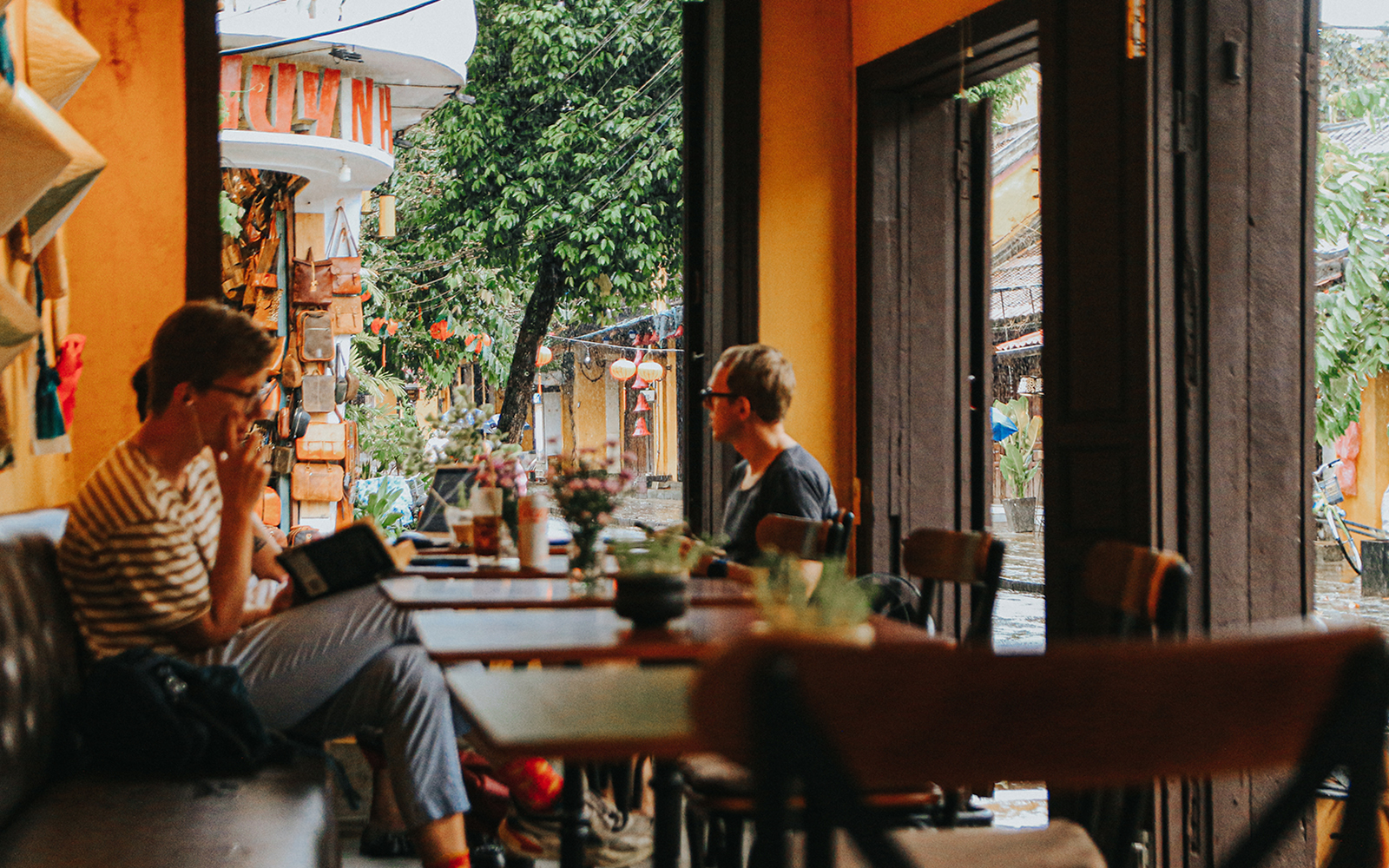 Tourist reading inside a small cafe in Hoi An, Vietnam.