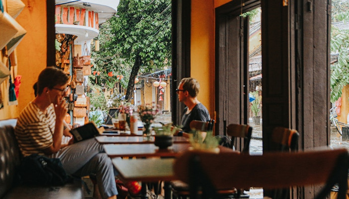 Tourist reading inside a small cafe in Hoi An, Vietnam.