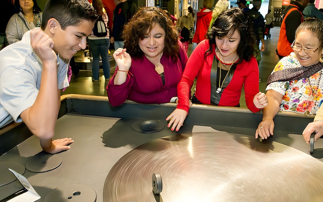 Visitors engaging with a spinning exhibit at the Exploratorium in San Francisco.