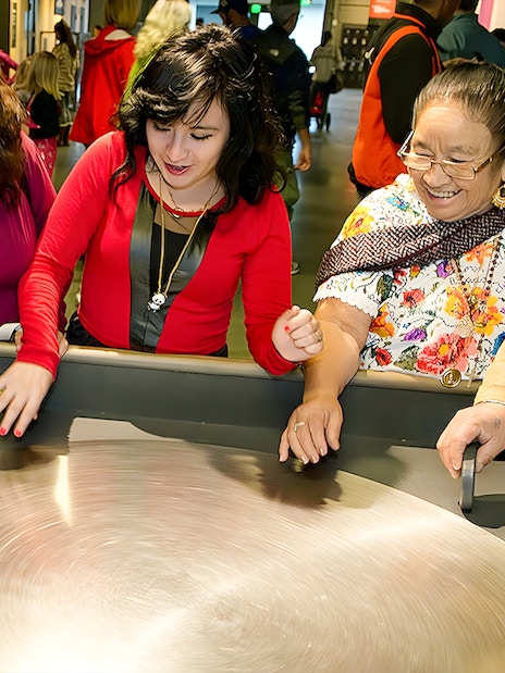 Visitors engaging with a spinning exhibit at the Exploratorium in San Francisco.