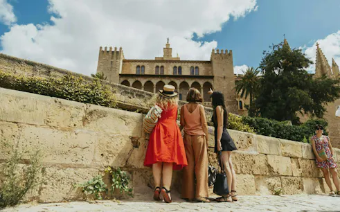 Tourists in front of Royal Palace of La Almudaina, Palma de Mallorca, Spain.
