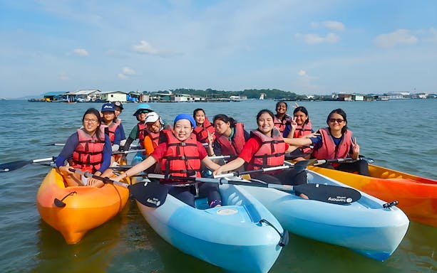 Kayakers in life vests paddling near floating houses at Pulau Ubin, Singapore.