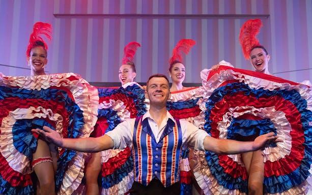 Cabaret performers in colorful costumes on a cruise with 3-course dinner.