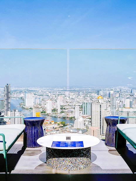 Rooftop seating area overlooking Bangkok skyline from Mahanakhon SkyWalk, Thailand.