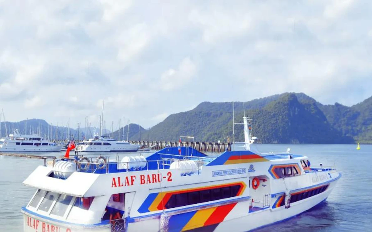 Ferry departing from Koh Lipe to Langkawi with scenic mountain backdrop.