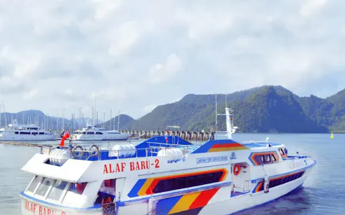 Ferry departing from Koh Lipe to Langkawi with scenic mountain backdrop.