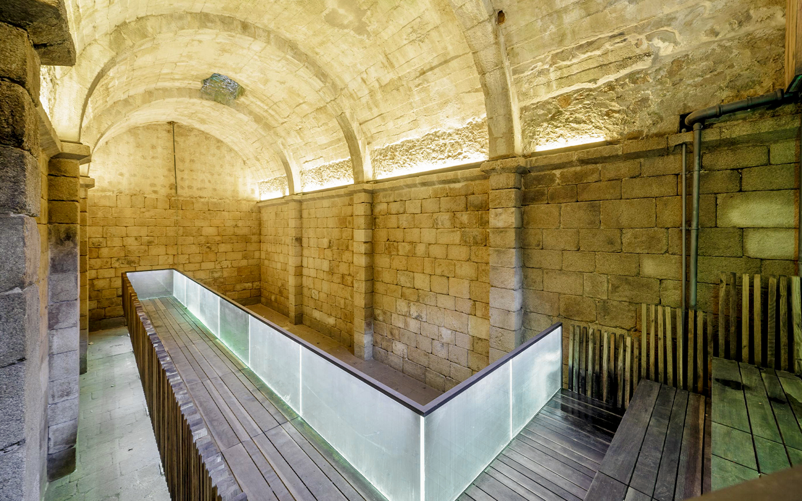 Ancient stone arches and moss-covered walls in Moorish Castle Cistern, Sintra, Portugal.