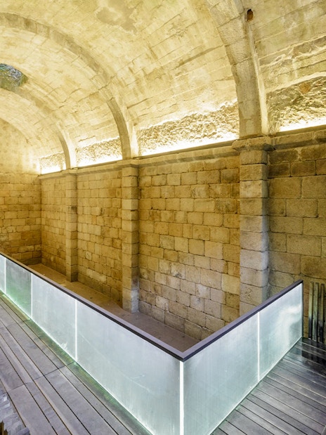 Ancient stone arches and moss-covered walls in Moorish Castle Cistern, Sintra, Portugal.