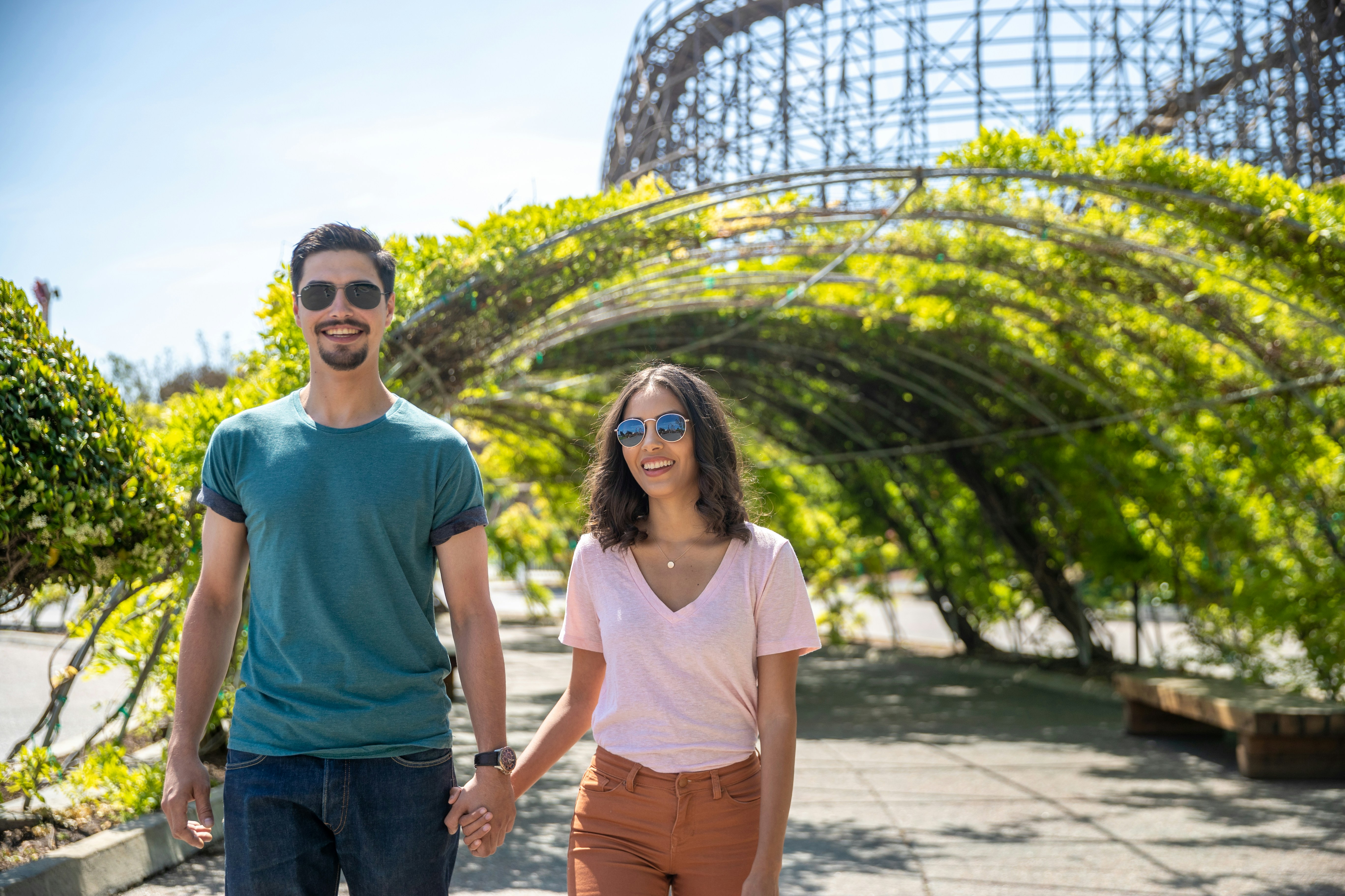 Couple walking under a green arbor at California's Great America.