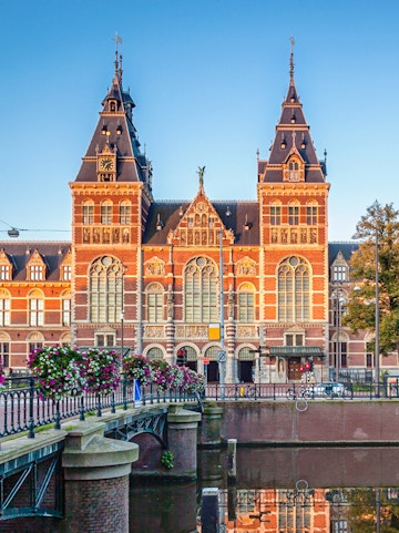 Rijksmuseum facade with canal and bridge in Amsterdam.