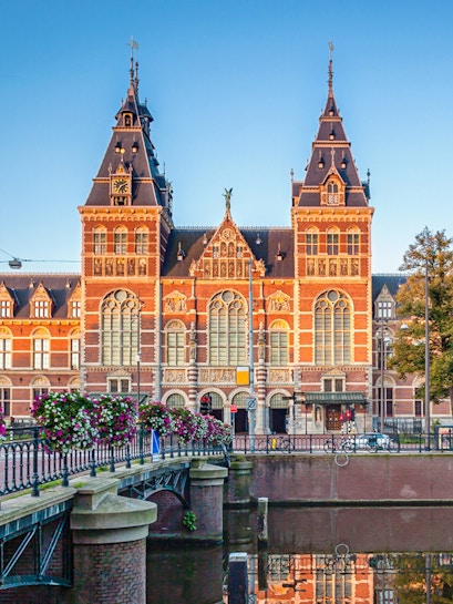 Rijksmuseum facade with canal and bridge in Amsterdam.