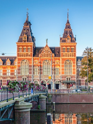 Rijksmuseum facade with canal and bridge in Amsterdam.