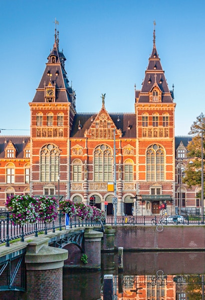 Rijksmuseum facade with canal and bridge in Amsterdam.