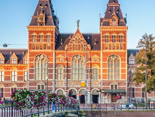 Rijksmuseum facade with canal and bridge in Amsterdam.