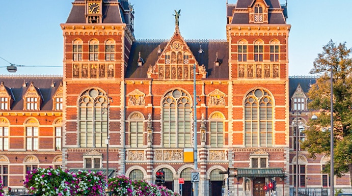 Rijksmuseum facade with canal and bridge in Amsterdam.