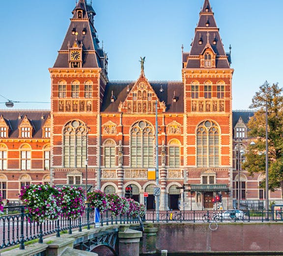 Rijksmuseum facade with canal and bridge in Amsterdam.