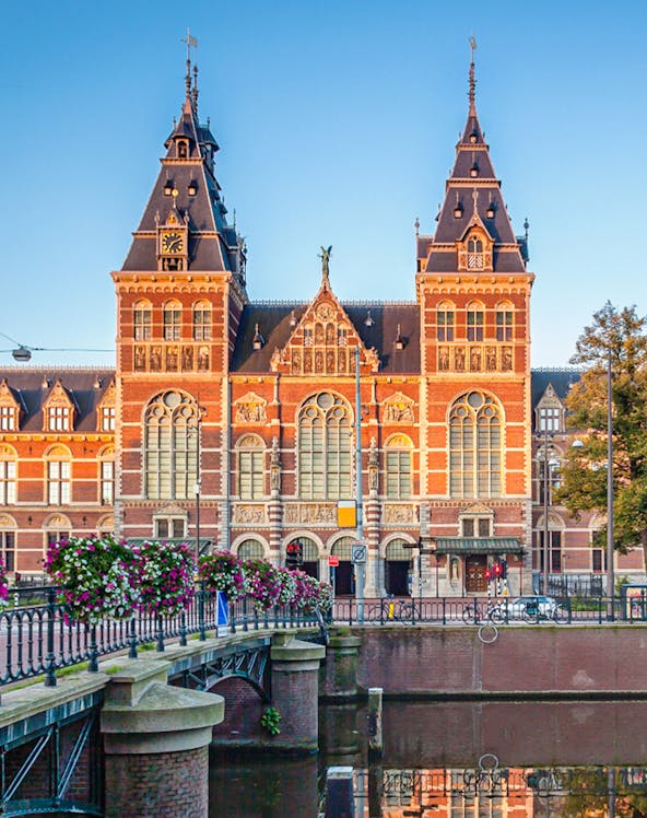Rijksmuseum facade with canal and bridge in Amsterdam.