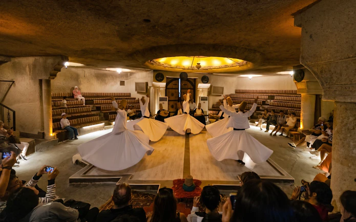 Whirling Dervishes performing Sema Ceremony in a traditional setting with audience.