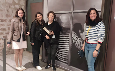 Tourists with guide at Picasso Museum, standing by a large photo of Picasso.