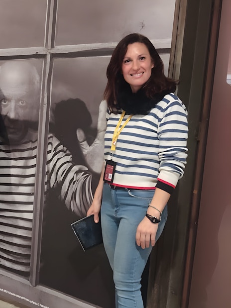 Tourists with guide at Picasso Museum, standing by a large photo of Picasso.