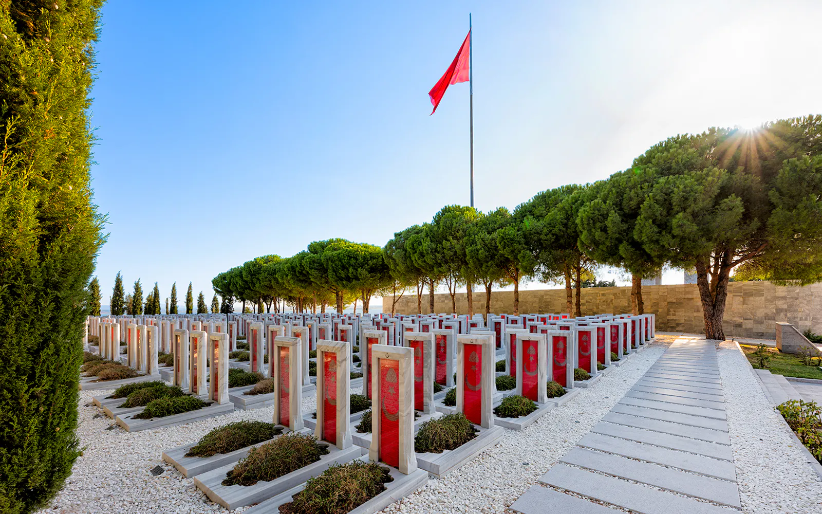 Canakkale Martyrs Memorial Cemetery with red headstones and Turkish flag in Gallipoli.
