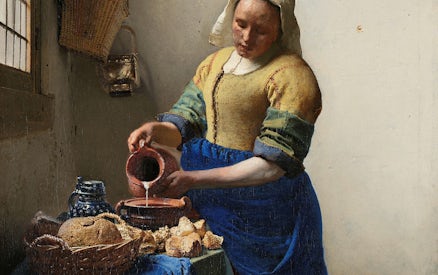 Woman pouring milk in Vermeer's "The Milkmaid" at Rijksmuseum, Amsterdam.
