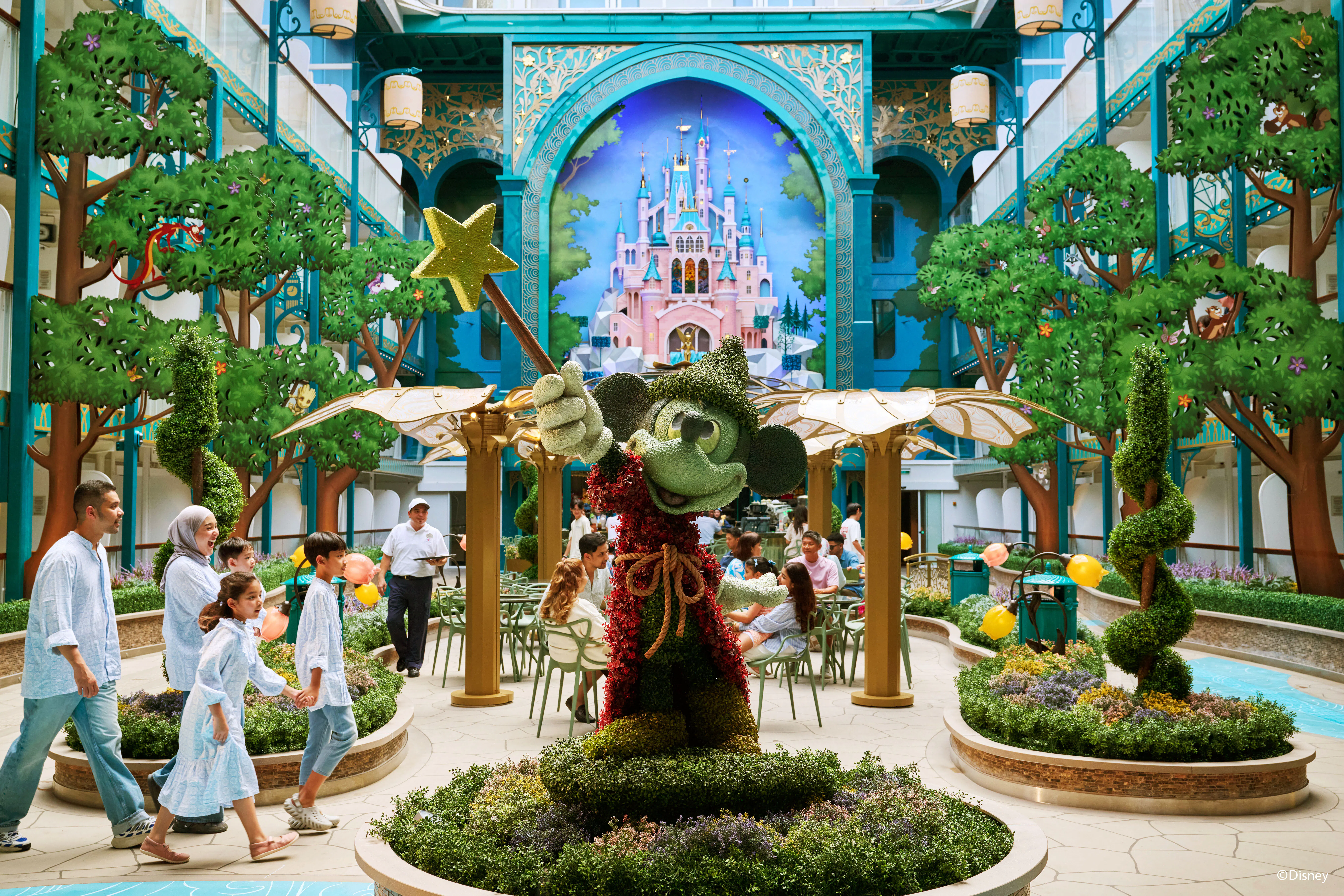 Imagination Garden on Disney Cruise Line with Mickey Mouse topiary and castle mural.