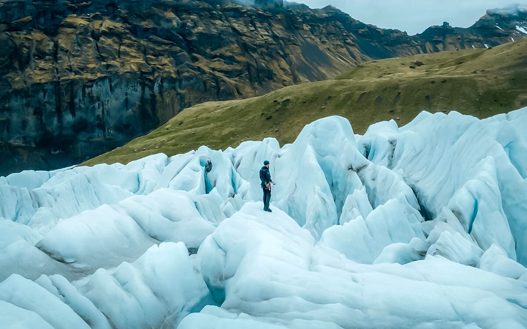 Explorer navigating ice maze and glacier crevasses in Skaftafell, Iceland.