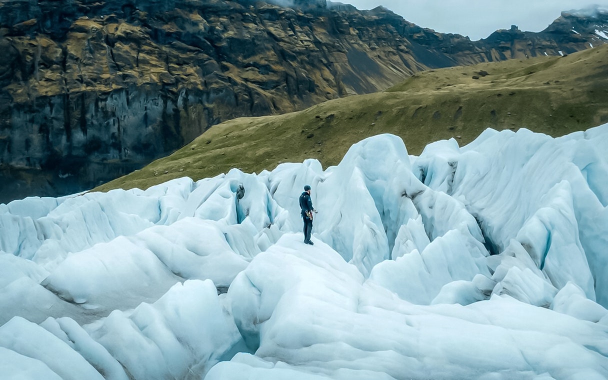 Explorer navigating ice maze and glacier crevasses in Skaftafell, Iceland.