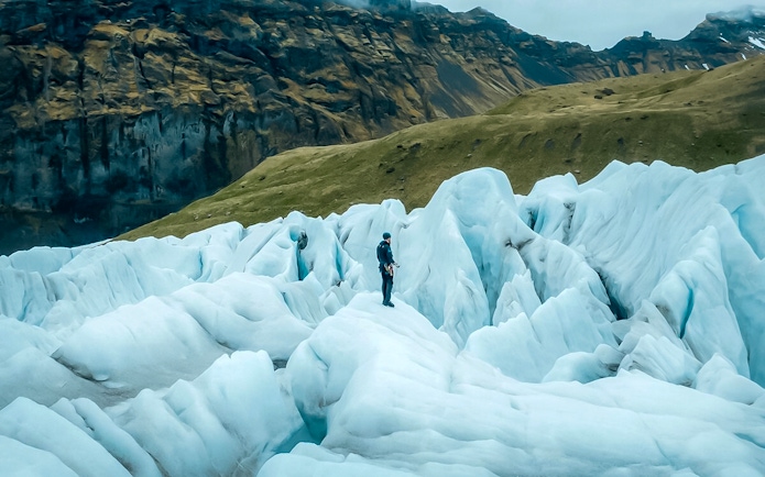 Explorer navigating ice maze and glacier crevasses in Skaftafell, Iceland.