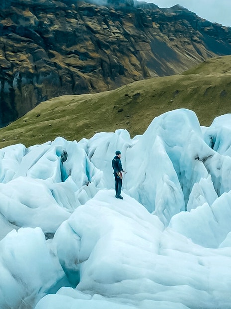 Explorer navigating ice maze and glacier crevasses in Skaftafell, Iceland.