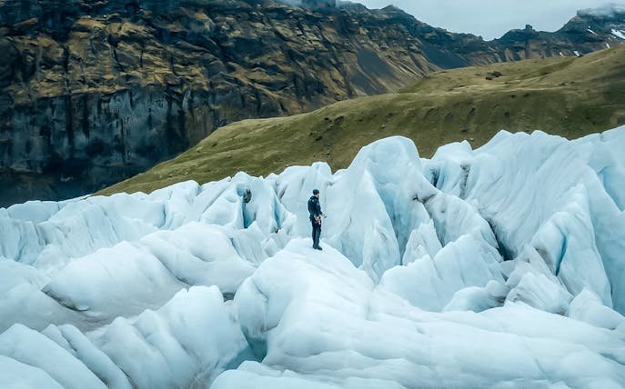 Explorer navigating ice maze and glacier crevasses in Skaftafell, Iceland.