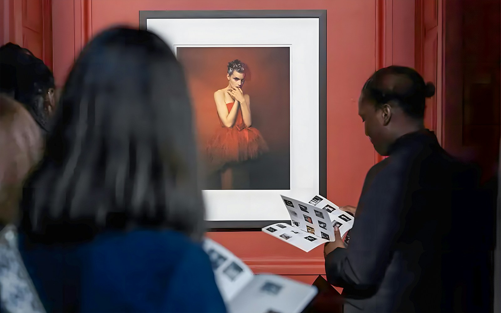 Visitors viewing artwork at Palais Galliera exhibit in Paris.