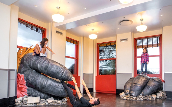 Children playing on giant gorilla hands at Empire State Building Observatory, New York City.