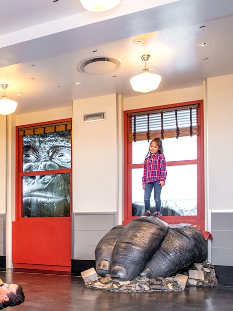Children playing on giant gorilla hands at Empire State Building Observatory, New York City.