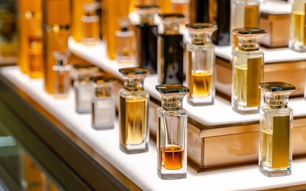 Elite perfumery bottles displayed in a luxury shopping mall store.
