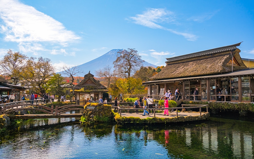 Visitors at Oshino Hakkai ponds with Mount Fuji in the background, Japan.