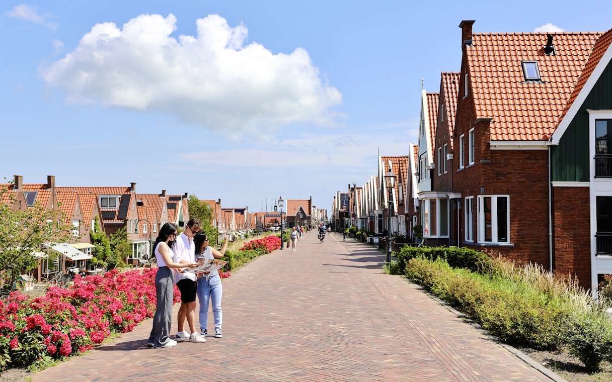 Tourists exploring the picturesque streets of Volendam with traditional Dutch houses.