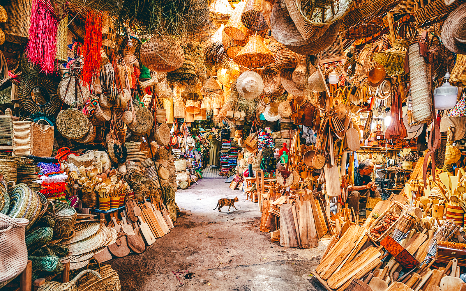 Bustling market stall with woven baskets and wooden crafts in Marrakech souk, Morocco.