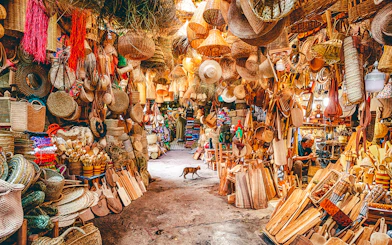 Bustling market stall with woven baskets and wooden crafts in Marrakech souk, Morocco.