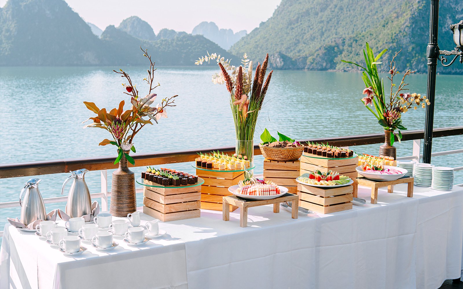 Buffet setup on Ambassador cruise deck with scenic view of water and mountains.