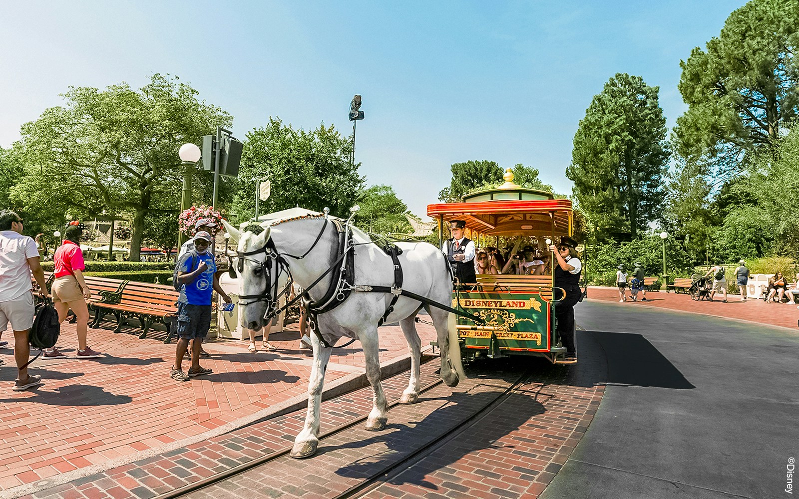 Horse-drawn streetcar on Main Street, Disneyland Paris, with passengers enjoying the ride.