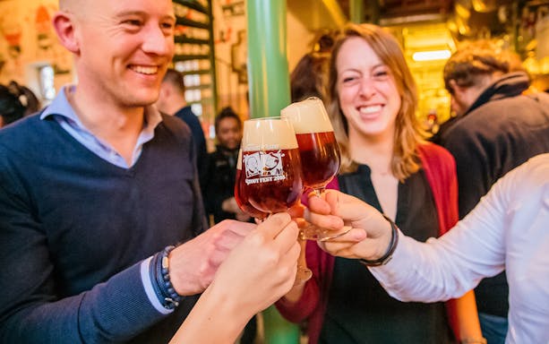 Group toasting with craft beer at a brewery tour.