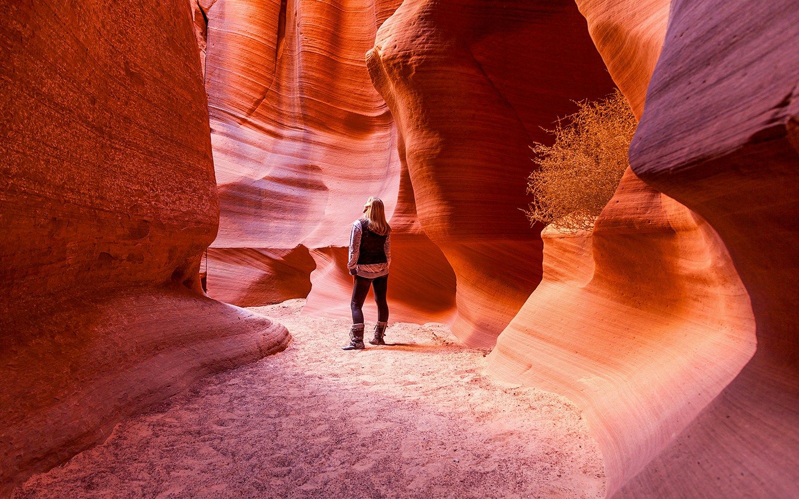 Visitor exploring the narrow sandstone walls of Antelope Canyon X, Arizona.