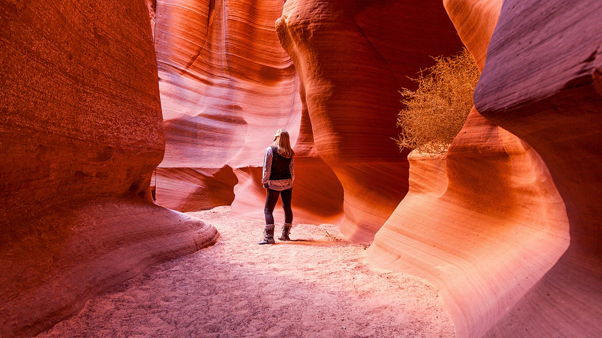 Visitor exploring the narrow sandstone walls of Antelope Canyon X, Arizona.