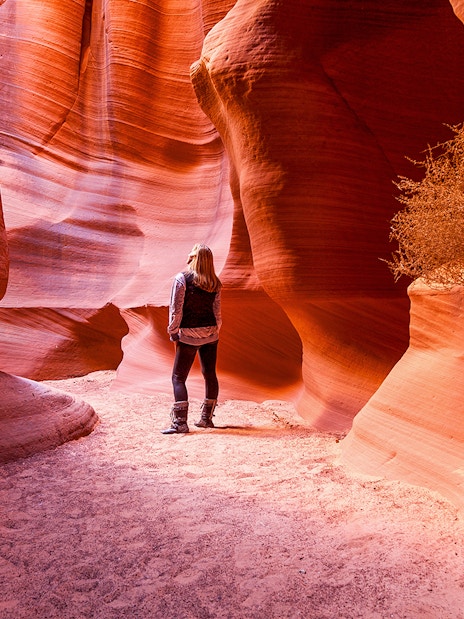 Visitor exploring the narrow sandstone walls of Antelope Canyon X, Arizona.